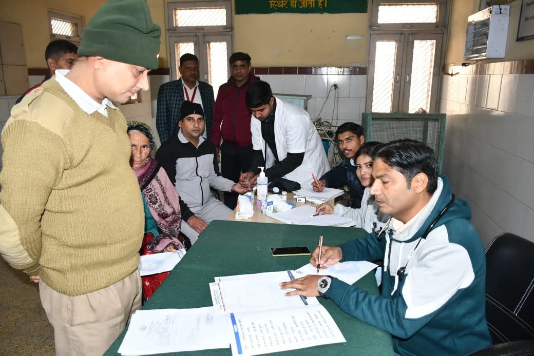 Dr. Riaz Ahmad evaluating patients and writing prescriptions